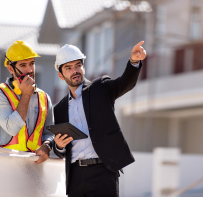 Ingeniero y técnico con casco inspeccionando un edificio